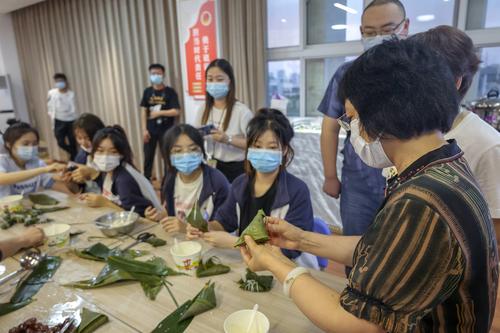 4.校长韦艳春为同学们示范包粽子(1)